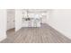 Open concept living space with gray laminate flooring, white walls, and a modern kitchen at 5469 Helen Pl Sw, Mableton, GA 30126