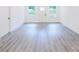 Bright living space with gray laminate flooring, white walls, a door, and large windows providing natural light at 5469 Helen Pl Sw, Mableton, GA 30126