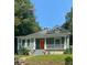 Charming home featuring a cozy front porch, orange front door and verdant lawn at 693 Dill Sw Ave, Atlanta, GA 30310