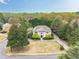 Aerial view of home with large lot, mature trees, circular driveway and professionally landscaped at 7415 Northampton Ct, Cumming, GA 30040
