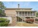 Multi-level backyard featuring a screened porch, patio, stone retaining wall, and lush landscaping at 7415 Northampton Ct, Cumming, GA 30040