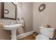 Cozy powder room with pedestal sink, decorative mirror, and neutral color palette at 7415 Northampton Ct, Cumming, GA 30040