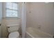 Clean, bright bathroom featuring tiled shower-tub combo with window at 7415 Northampton Ct, Cumming, GA 30040