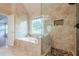 Luxurious bathroom featuring a soaking tub, glass enclosed shower, and decorative windows at 7415 Northampton Ct, Cumming, GA 30040