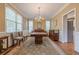 Formal dining room with chandelier, large windows, hardwood floors, and elegant furnishings at 7415 Northampton Ct, Cumming, GA 30040