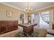 Formal dining room with chandelier, large windows, hardwood floors, and elegant furnishings at 7415 Northampton Ct, Cumming, GA 30040