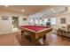 Spacious entertainment room with a red billiard table, wood floors, and a door to a full bathroom at 7415 Northampton Ct, Cumming, GA 30040