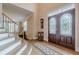 Inviting entryway featuring hardwood floors, decorative glass double doors, and staircase with access to the second story at 7415 Northampton Ct, Cumming, GA 30040