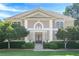 Elegant two-story home with a symmetrical facade, manicured lawn, and mature landscaping at 7415 Northampton Ct, Cumming, GA 30040