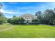 Spacious front yard with a traditional home, mature trees, and manicured landscaping at 7415 Northampton Ct, Cumming, GA 30040