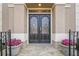 Close up of an ornate front door surrounded by potted flowers and flagstone pavers at 7415 Northampton Ct, Cumming, GA 30040