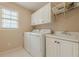 Efficient laundry room equipped with a washing machine, dryer, sink, and plenty of cabinet space at 7415 Northampton Ct, Cumming, GA 30040
