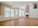 Open-concept living room with hardwood floors, large windows, and fireplace at 7415 Northampton Ct, Cumming, GA 30040