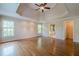 Large main bedroom with hardwood floors, tray ceilings, and access to the ensuite bathroom and walk-in closet at 7415 Northampton Ct, Cumming, GA 30040