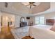 Bright primary bedroom with a trey ceiling, hardwood floors, large windows, and classic wood furnishings at 7415 Northampton Ct, Cumming, GA 30040