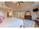 Bright primary bedroom with a trey ceiling, hardwood floors, walk-in closets, and comfortable furnishings at 7415 Northampton Ct, Cumming, GA 30040