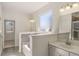 Bright bathroom featuring a soaking tub, a white vanity, and a window providing natural light at 13244 Tolstoy, Covington, GA 30014