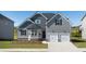 Charming two-story home with a two-car garage, manicured lawn, and gray wood siding, creating a welcoming curb appeal at 13244 Tolstoy, Covington, GA 30014