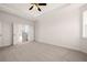 Spacious main bedroom with plush carpet, ceiling fan, and ensuite bathroom access, bathed in soft, natural light at 13244 Tolstoy, Covington, GA 30014