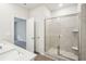 Bathroom showcasing tiled shower with glass door, white quartz vanity, and gray vinyl flooring at 3953 Brushy St, Powder Springs, GA 30127