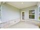 Covered patio with brick base and a white door and window at 3953 Brushy St, Powder Springs, GA 30127