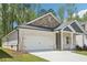 Inviting home exterior with brick siding, attached two-car garage and a well-kept lawn surrounded by mature trees at 3953 Brushy St, Powder Springs, GA 30127