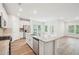 Contemporary kitchen showcasing a large island, stainless steel appliances, and an open layout connecting to a bright living space at 3953 Brushy St, Powder Springs, GA 30127