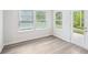 Living Room featuring vinyl flooring, three windows, and glass panel door to exterior at 3953 Brushy St, Powder Springs, GA 30127