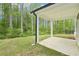 This backyard features green lawn, covered patio, and an abundance of trees at 3961 Brushy St, Powder Springs, GA 30127