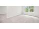 Bright bedroom with plush carpet, neutral walls, and windows with views of outside foliage at 3961 Brushy St, Powder Springs, GA 30127