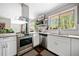 Modern kitchen with stainless steel appliances, white cabinetry, and a window overlooking the serene outdoors at 4595 Fradon Ct, Atlanta, GA 30349