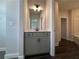Bathroom vanity with gray cabinet and modern lighting fixture at 5458 Summer Pine Pl, Buford, GA 30518