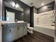 Well-lit bathroom with white cabinets, dark walls, and a shower-tub combo at 5458 Summer Pine Pl, Buford, GA 30518