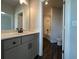 Bathroom vanity with gray cabinet, dark fixtures, and vinyl flooring at 5458 Summer Pine Pl, Buford, GA 30518