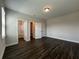 A bright bedroom showcases dark floors, neutral walls, and access to a bathroom and walk-in closet at 5458 Summer Pine Pl, Buford, GA 30518