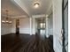 Elegant dining room with dark wood floors, white wainscoting, and a stylish chandelier at 5458 Summer Pine Pl, Buford, GA 30518