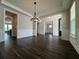 Spacious dining area featuring dark wood floors, elegant chandelier, and ample natural light at 5458 Summer Pine Pl, Buford, GA 30518