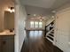 Inviting entryway featuring hardwood floors and a staircase, with access to the living area and half bath at 5458 Summer Pine Pl, Buford, GA 30518