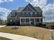 Charming brick two-story home with a covered front porch and well-manicured lawn at 5458 Summer Pine Pl, Buford, GA 30518
