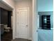 Hallway view showcasing access to a bathroom and a bedroom with neutral paint scheme and carpeted flooring at 5458 Summer Pine Pl, Buford, GA 30518