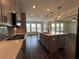 Open concept kitchen with large island, pendant lighting, stainless appliances, and hardwood flooring at 5458 Summer Pine Pl, Buford, GA 30518