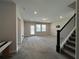 Large carpeted living room with a staircase and neutral walls at 5458 Summer Pine Pl, Buford, GA 30518