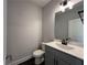 Well-lit powder room featuring modern fixtures, a sink with vanity, and a toilet at 5458 Summer Pine Pl, Buford, GA 30518