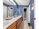 Bathroom with blue textured walls, wood vanity, and a shower-tub combination at , Stone Mountain, GA 30088
