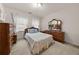 Traditional bedroom features a full bed with light colored bedding and matching wood furniture at , Stone Mountain, GA 30088