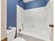A bathtub and white tiled shower area with blue textured walls at , Stone Mountain, GA 30088