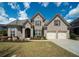 Charming brick home featuring a manicured lawn, two-car garage, and an inviting front entrance at 2557 Staunton Dr, Duluth, GA 30097
