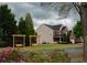 Charming home exterior with swings, mature trees, manicured lawn, and colorful flowerbeds at 2557 Staunton Dr, Duluth, GA 30097