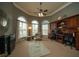 Well-lit home office with custom built-ins, comfortable seating and ceiling fan at 2557 Staunton Dr, Duluth, GA 30097