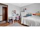 Bright bedroom featuring a desk, white comforter, and warm-toned wood floors at 525 Penny Ln, Woodstock, GA 30188